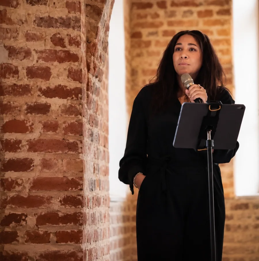 Jessica Huber spricht mit Mikrofon vor einer Backsteinwand — Workshop Sprachlos war gestern in Köln
